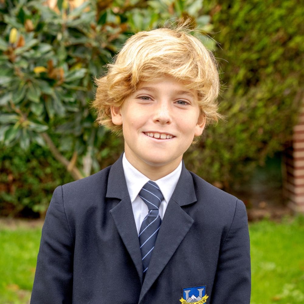 Estudiante joven del colegio Highlands en El Encinar con uniforme formal, fotografiado en un entorno verde próximo a La Moraleja.